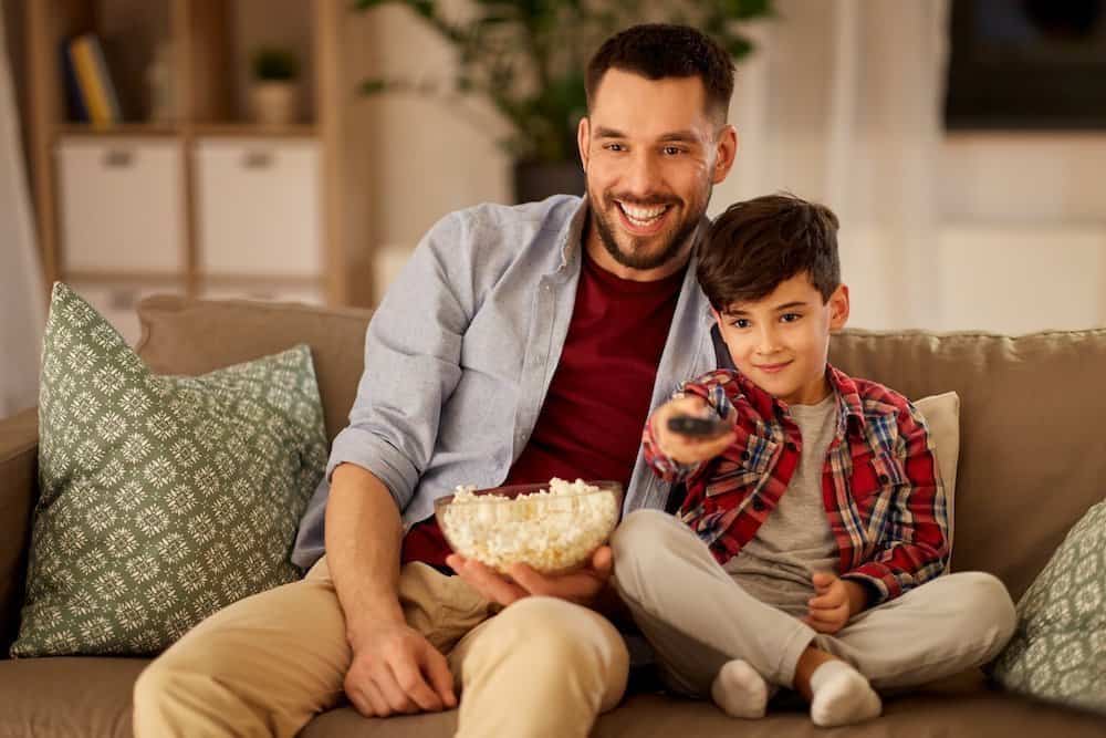 Father and Son enjoying movie theater popcorn at home